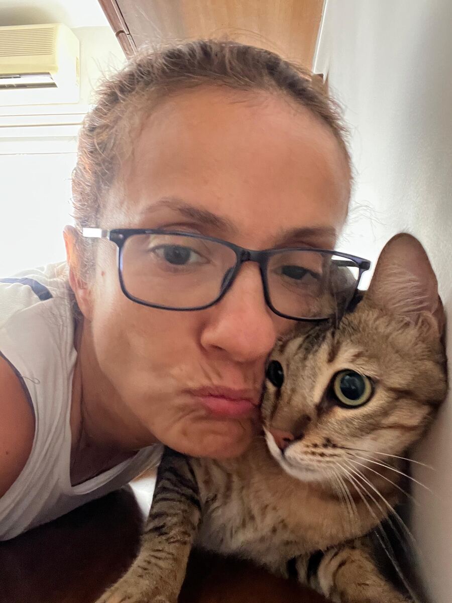 Sausan pressing her cheek against a wide-eyed tabby cat